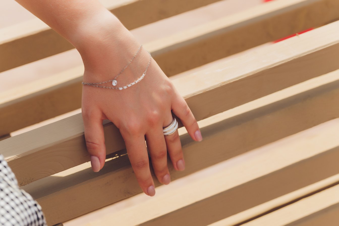 close up of boho styled woman hands with silver jewelry.